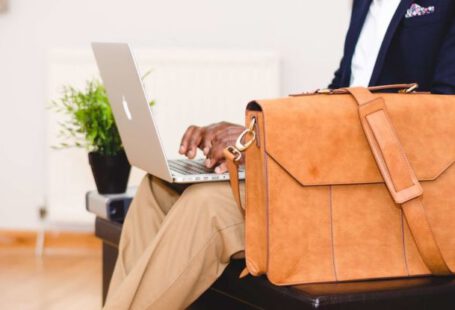 Laptop Bag - Person Wearing Blue Suit Beside Crossbody Bag and Using Macbook