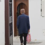 Carry-On Bag - A man walking down a narrow alleyway with a bag