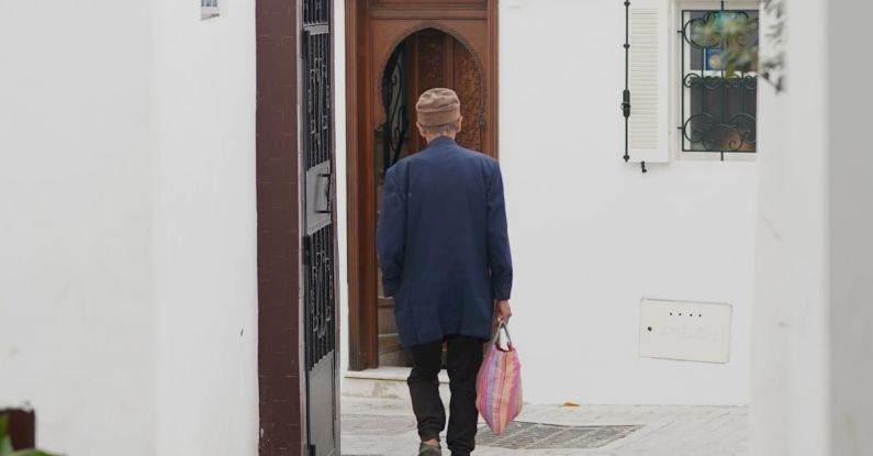 Carry-On Bag - A man walking down a narrow alleyway with a bag
