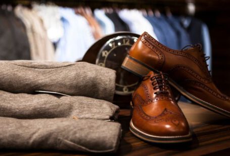 Leather Shoes - Pair of Brown Leather Wingtip Shoes Beside Gray Apparel on Wooden Surface