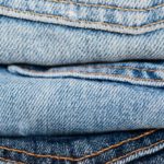 Quality Denim - Stack of blue jeans arranged by color