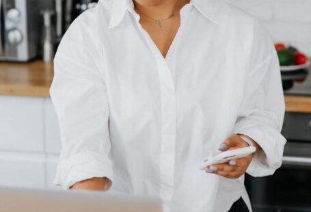 Button-Up Shirt - Woman in White Button-Up Shirt Using a Laptop and a Cellphone