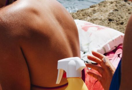 UV Protection - Women Applying Sun Cream on a Sunny Beach
