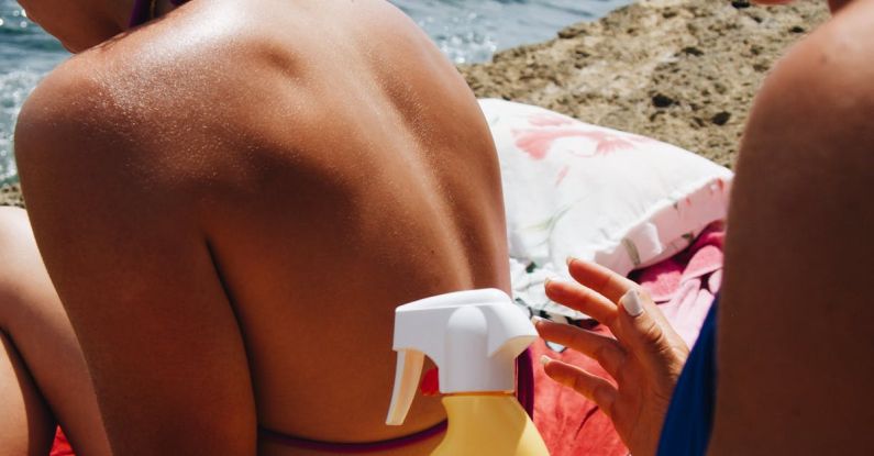 UV Protection - Women Applying Sun Cream on a Sunny Beach