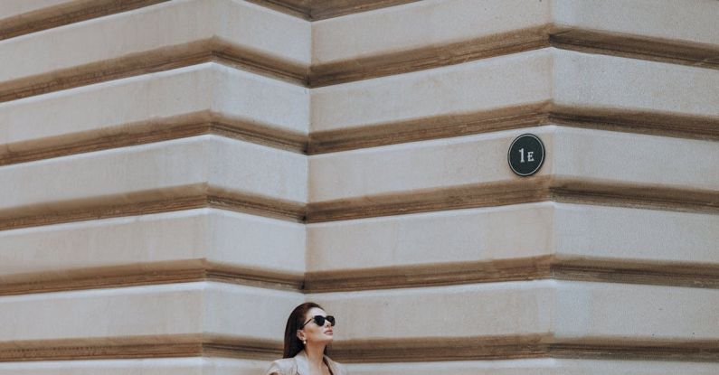 Sunglasses Fit - Full body of elegant woman in sunglasses wearing stylish clothes and high heels standing near wall of contemporary house on street